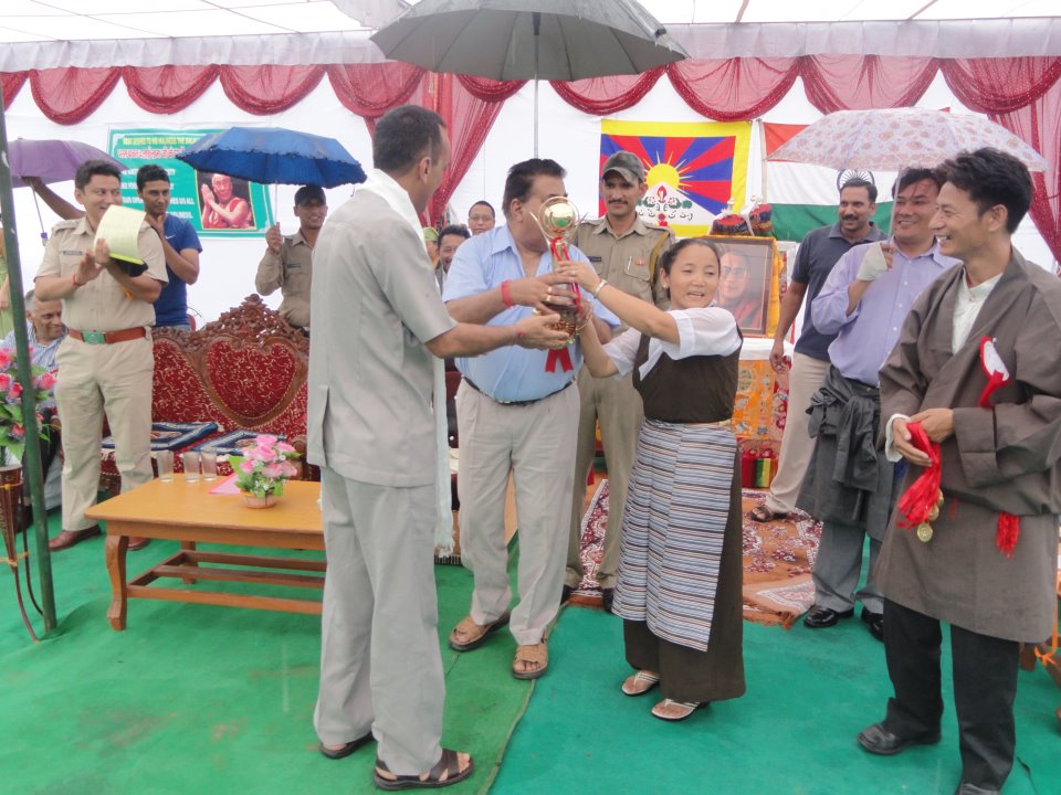 Superintendent of Police receiving "Trunkar Cup" from the Deputy Commissioner in Paonta Cholsum Settlement on the occasion of His Holiness the Dalai Lama's 77th birthday
