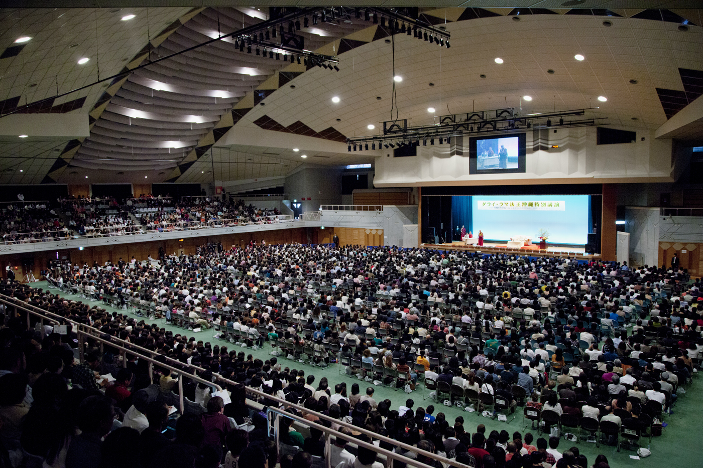 Thousands of people listening to His Holiness the Dalai Lama's talk at the Kenritsu Budo hall in Okinawa, Japan