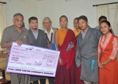 Members of the Tibetan delegation hand over donation for relief efforts to the chief minister.