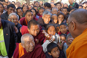 His Holiness the Dalai Lama greeting members of the audience as he arrives at the start of the eighth day of teachings at Sera Jey Monastery in Bylakuppe, India on January 1, 2014. Photo/Jeremy Russell/OHHDL