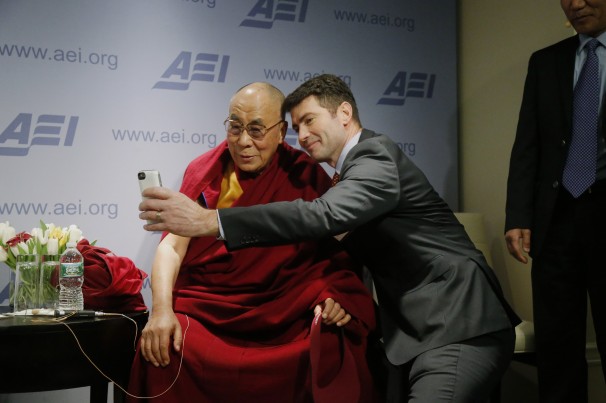 Charles Dharapak/AP - The Dalai Lama, posing for a selfie with blogger and activist Alek Boyd, discussed how to advance a “happy life’’ for people worldwide at the American Enterprise Institute in Washington on Thursday.