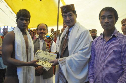 Sikyong presenting the prize to a winner of the traditional wrestling match.