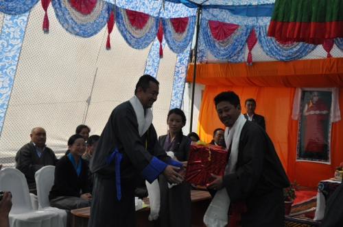 Health Kalon Dr. Tsering wangchuk presenting an award to a long-serving hospital staff.