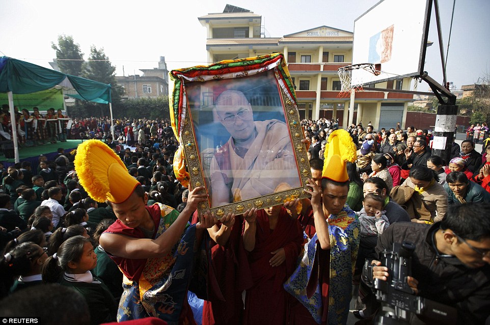 Universal role model: Young Tibetan monks carry a portrait of the Dalai Lama through the streets of Nepal.