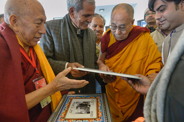 His Holiness the Dalai Lama is presented with photographs of his first visit to Sankisa in 1960 on final day of his three day visit to Sankisa, UP, India on February 1, 2015. Photo/Tenzin Choejor/OHHDL