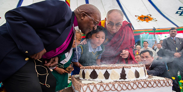 Archbishop Desmond Tutu, two young students and His Holiness the Dalai Lama blowing out candles on a birthday cake in celebration of His Holiness's 80th year during their visit to Tibetan Children's Village School (TCV) in UPper Dharamsala, HP, India on April 23, 2015. Photo/Tenzin Choejor/OHHDL