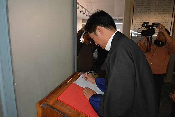 Sikyong writing his remarks on the visitor's diary, 30 April 2015.