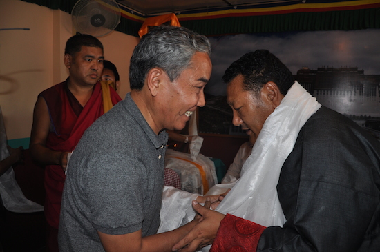 members of the Tibetan community presenting ceremonial scarves.
