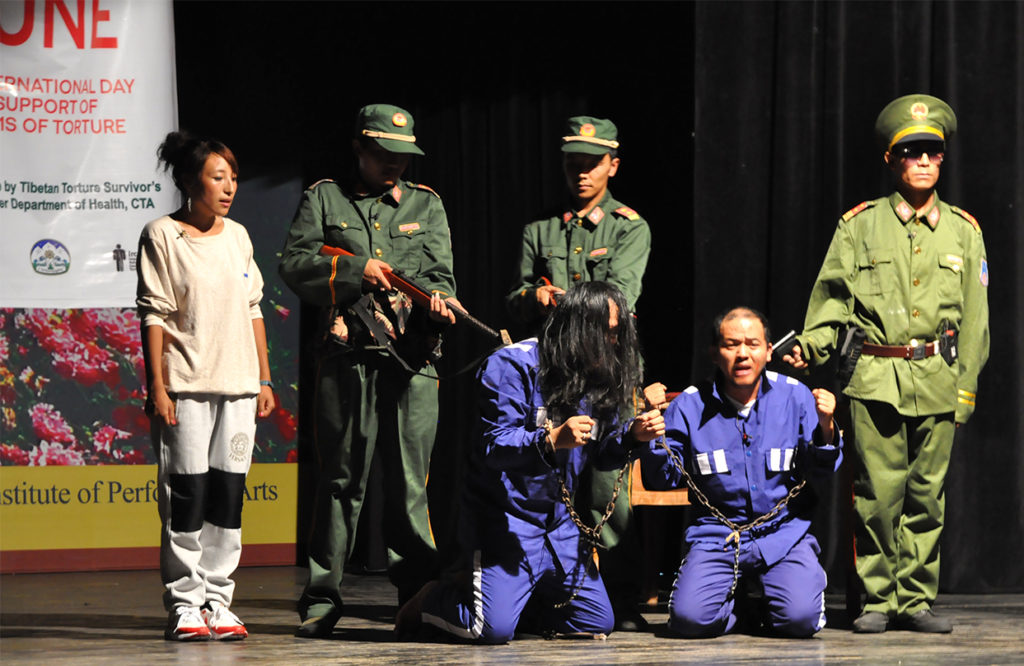 Actors performing a play on torture inflicted on tibetan prisoners by Chinese soldiers at TIPA to mark International Day in support of victims of torture, 26 June 2016.