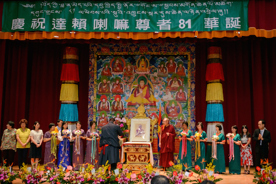 Representative Dawa Tsering and others offering ceremonial Tibetan scarves to a portrait of His Holiness the Dalai Lama.