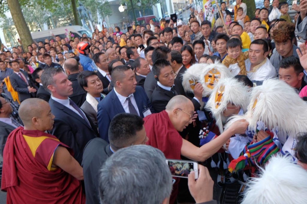 His Holiness the Dalai Lama greets an artist who was performing a traditional snow lion dance to welcome him at Brussels, Belgium.