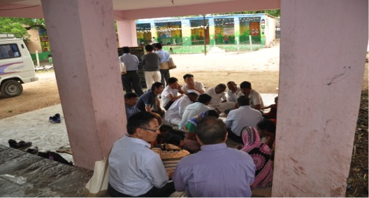 CRHP staff with the help of community doing social mapping of the village and at the far-end is the board displaying the monthly health statistics of the village