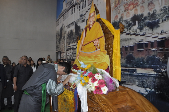 Sikyong offering Khatag to a lifesize cardboard figure of His Holiness the Dalai Lama at Dekyiling's Potala community hall.