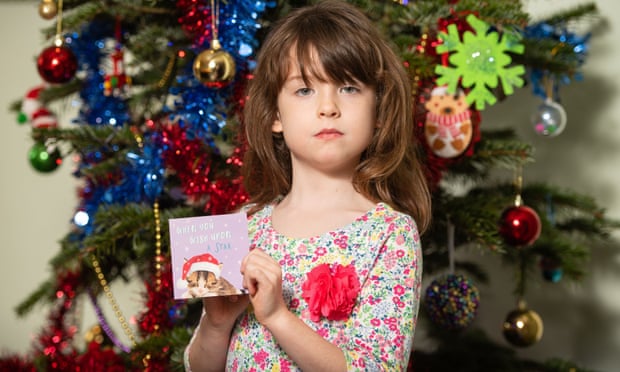Florence Widdicombe holding a Tesco Christmas card from the same pack that contained a message from a Chinese prisoner. Photograph: Dominic Lipinski/PA