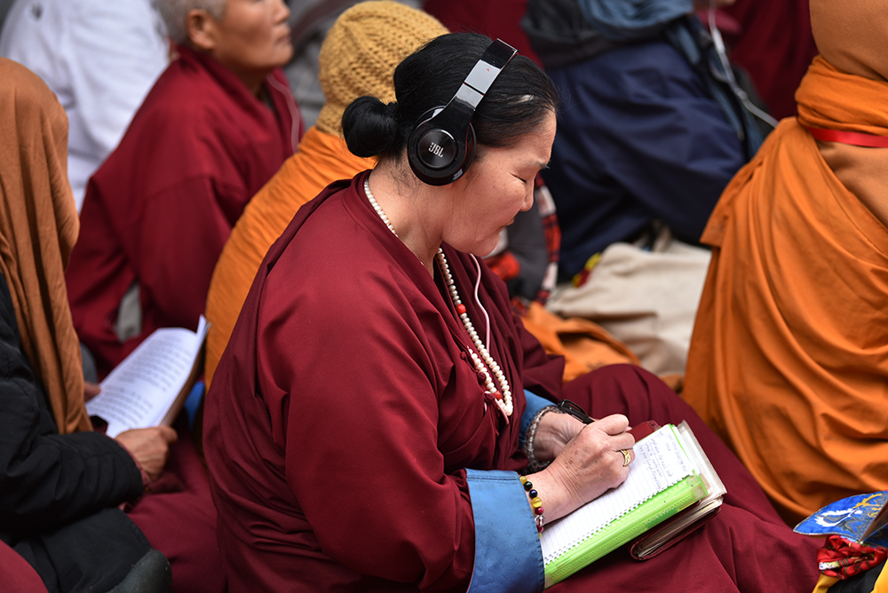 A follower taking down notes attentively during the teachings. Photo/ Pasang Dhondup/ CTA