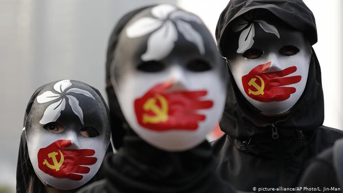 In this December 2019 photo, people wearing masks in Hong Kong are seen during a rally to show support for Uighurs and their fight for human rights in China. (AP Photo/Lee Jin-man)