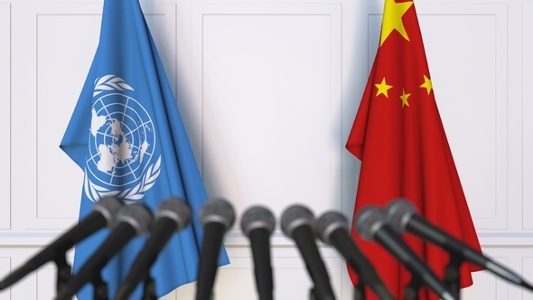 Flags of the United Nations and China at international meeting or negotiations press conference. Photo/VideoHive