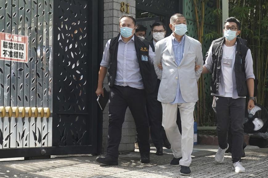  Hong Kong media tycoon Jimmy Lai, center, who founded newspaper Apple Daily, is arrested by police officers at his home in Hong Kong, Monday, August 10, 2020. © AP Photo