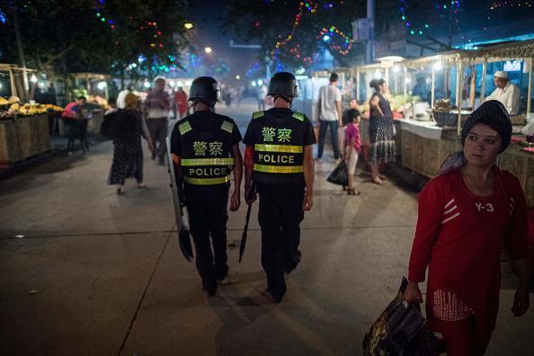 Chinese police patrol a night market near Id Kah Mosque in Xinjiang, a day before the Eid al-Fitr holiday, June 25, 2017. © 2017 AFP/Getty Images