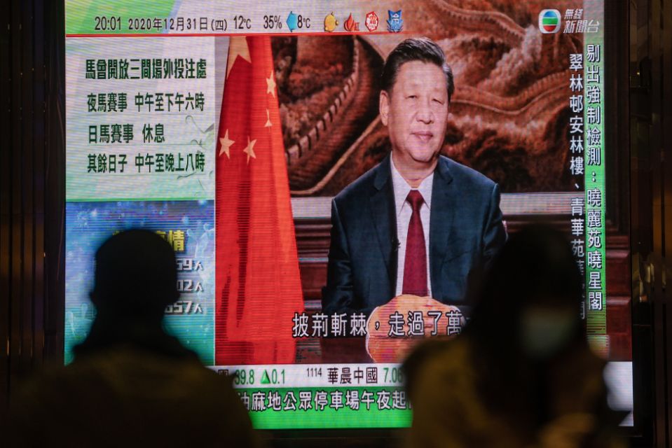 A news report on Chinese President Xi Jinping's New Year's Eve speech is shown on a public screen in Hong Kong, China, on Thursday, Dec. 31, 2020. This month Xi called on Communist Party officials in the 25-member Politburo to build a "holistic national security architecture" that would extend to "all aspects of the work of the party and the country." Photographer: Roy Liu/Bloomberg via Getty Images