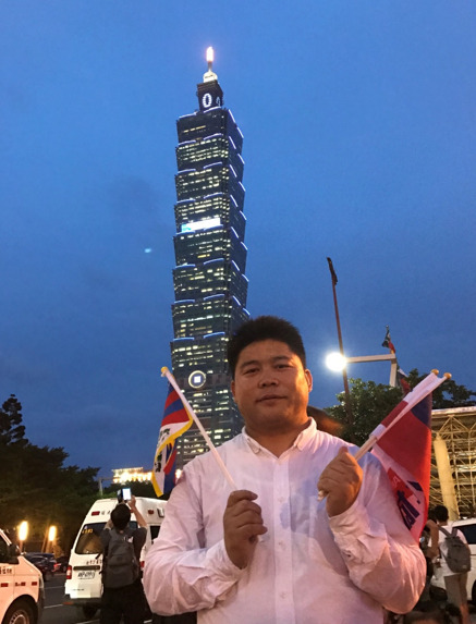 Mr Dawa holding Tibetan and Taiwanese flags during International University inter competition in Taipei, 2017. 